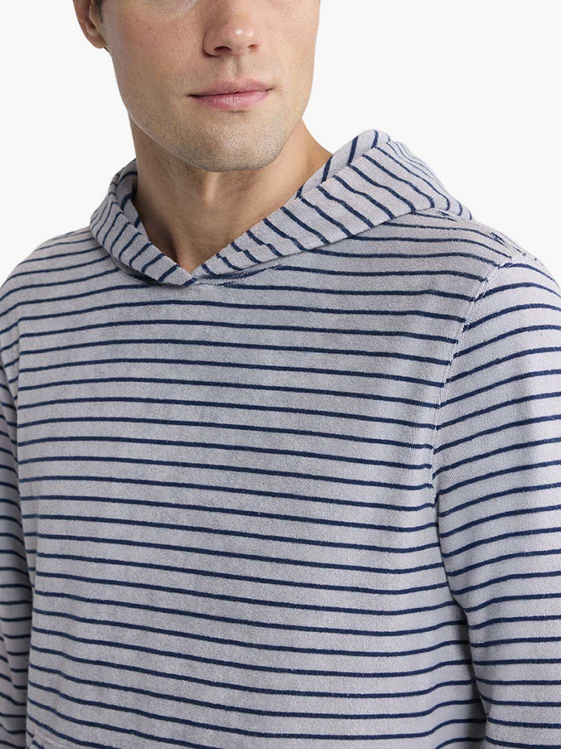 Man wearing a gray and navy striped terry hoodie with horizontal stripes throughout.