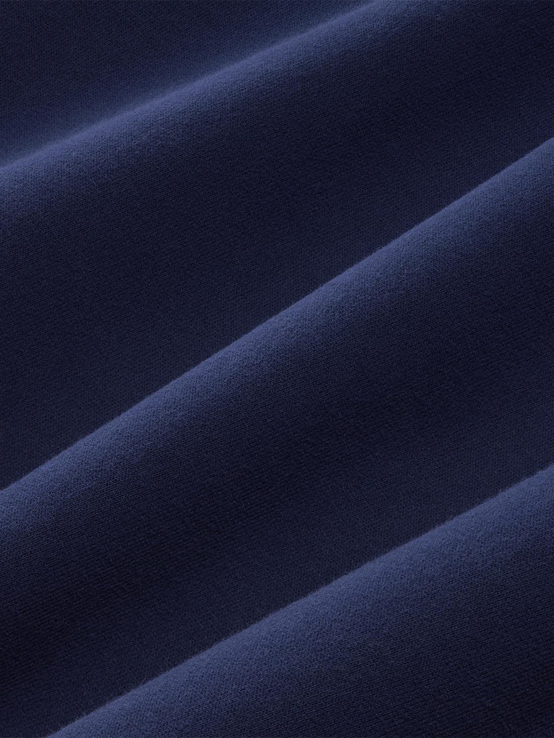 Navy blue crewneck sweatshirt with visible diagonal seams and textured knit fabric surface.