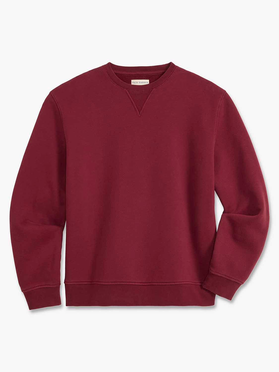 Burgundy crewneck sweatshirt with long sleeves and ribbed cuffs displayed on neutral background.