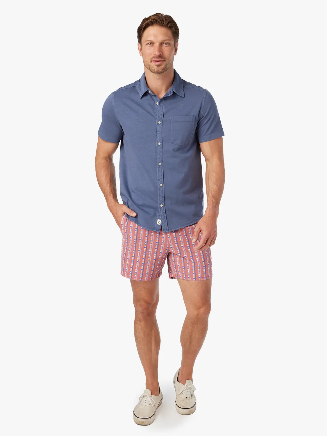 Man wearing a navy short-sleeved button-up shirt with a chest pocket and white buttons.