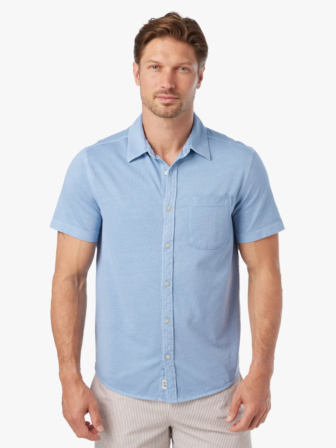 Man wearing a light blue short-sleeved button-up shirt with a chest pocket.