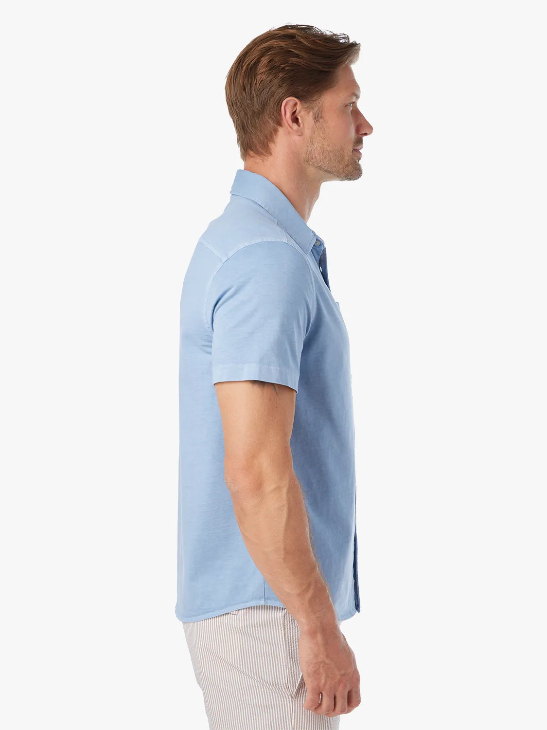 Man wearing a light blue short-sleeved collared shirt with a relaxed fit.