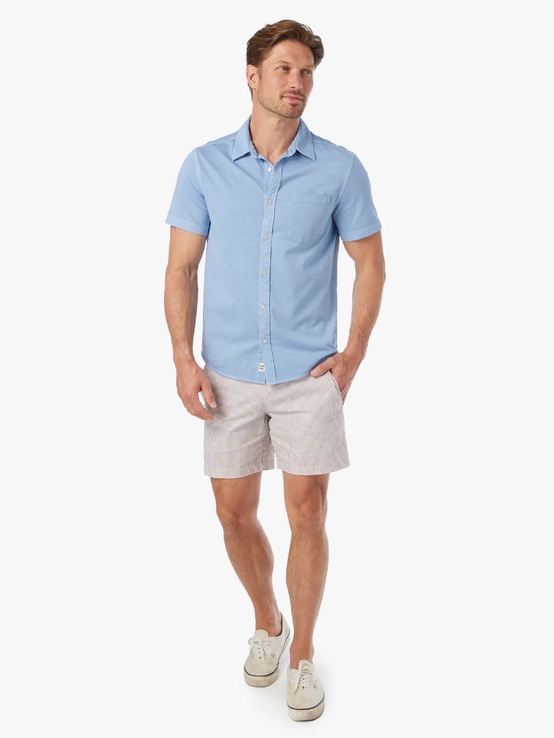 Man wearing a light blue short-sleeve button-up shirt with a chest pocket.