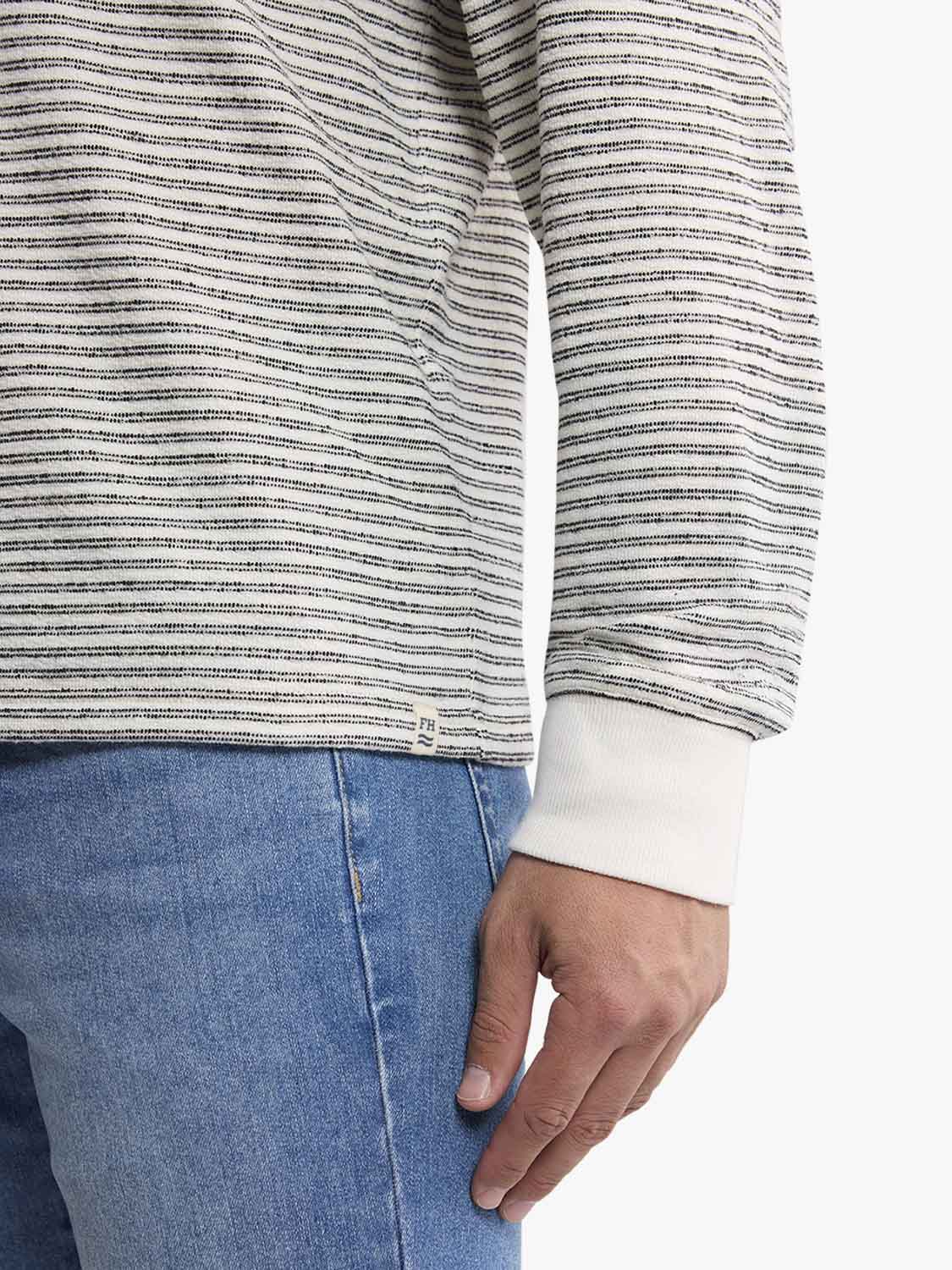 Cream and navy striped terry crewneck sweatshirt worn with blue denim jeans and white ribbed cuffs.