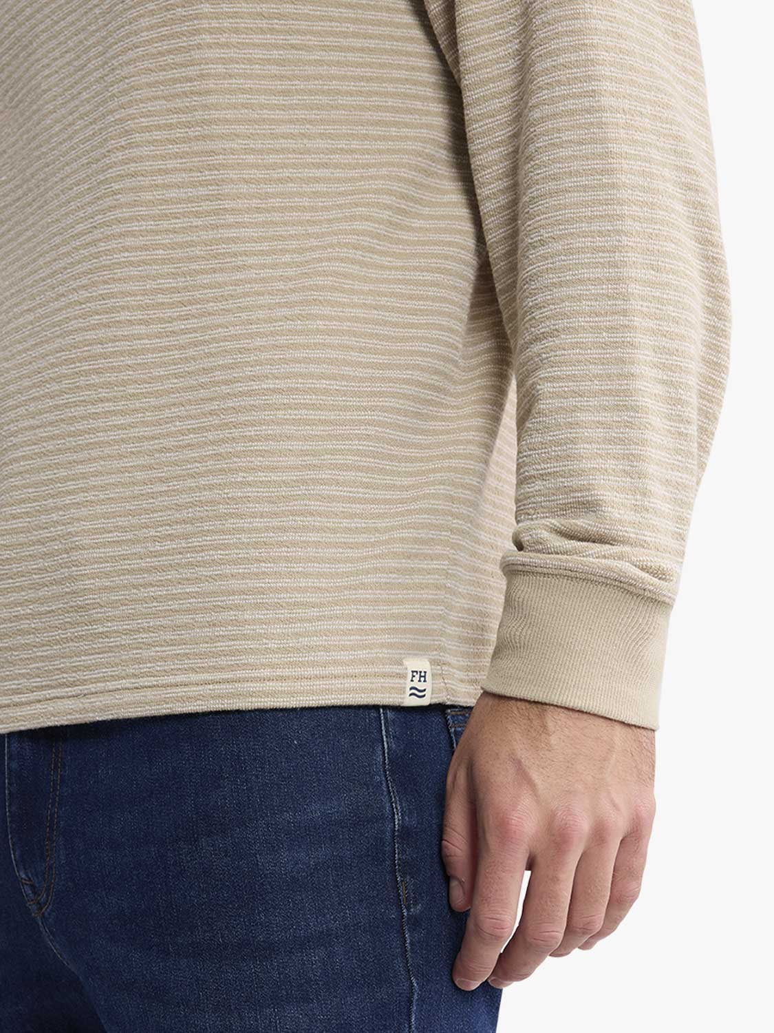 Beige striped terry crewneck sweatshirt worn with dark blue denim jeans displayed on model.