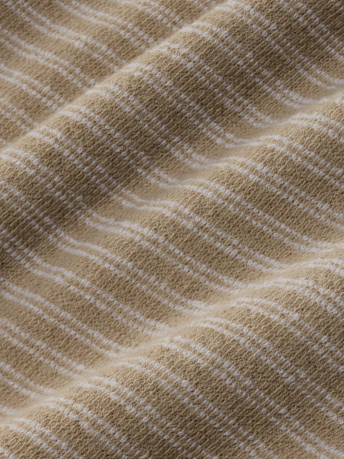 Natural terry crewneck features diagonal ribbed texture with subtle striping throughout the fabric.