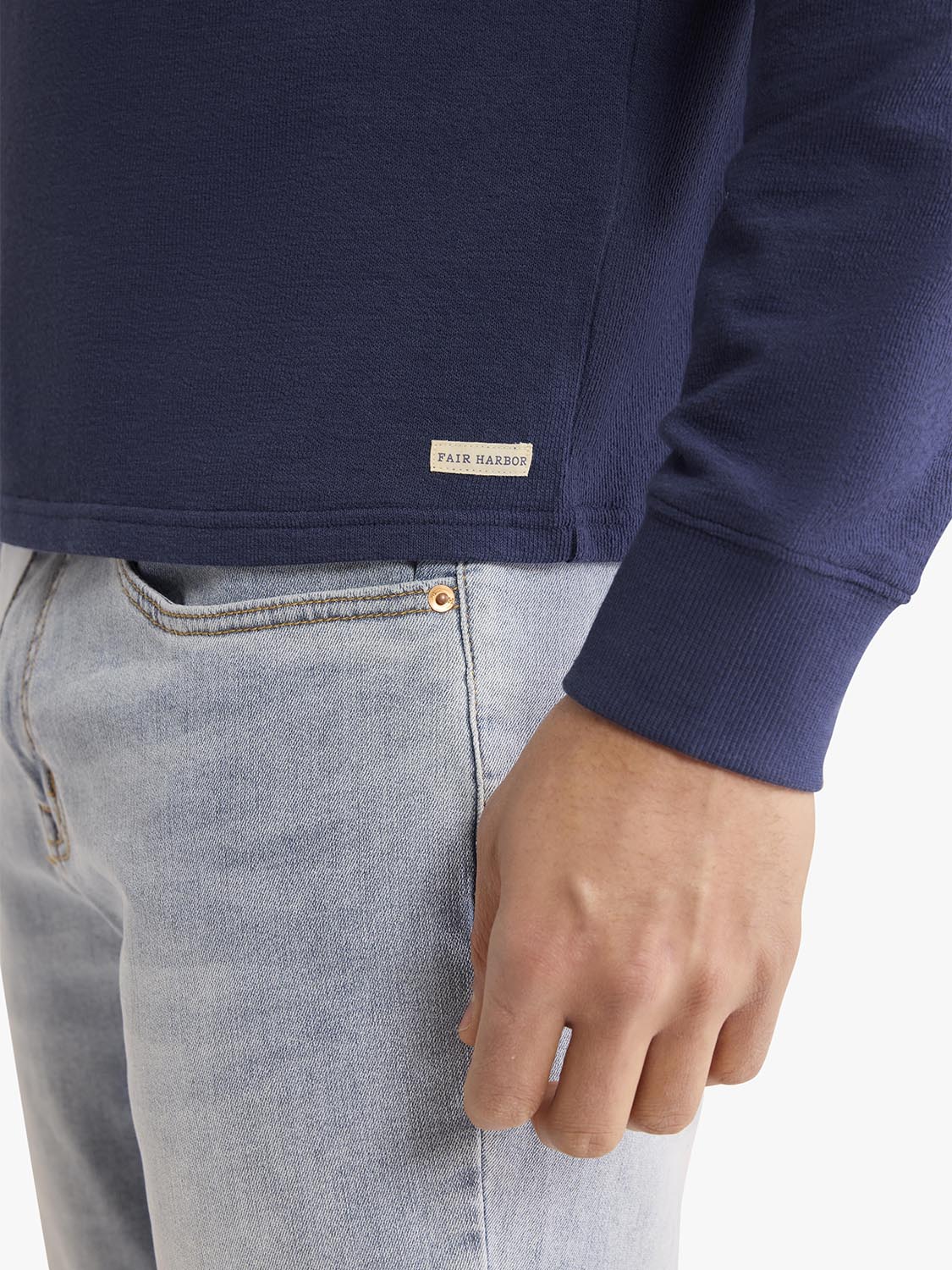 Navy terry crewneck sweatshirt with ribbed cuffs and Fair Harbor brand label visible.