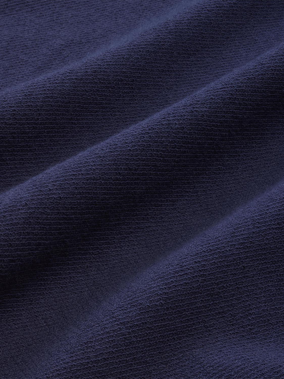 Close-up of navy terry cloth fabric showing textured weave and soft material surface.