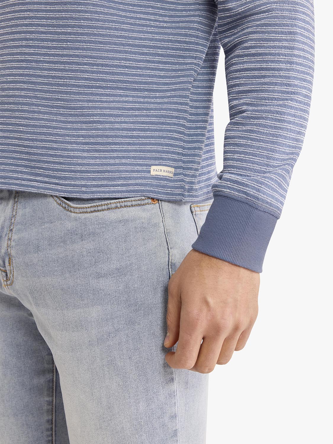 Blue and white striped crewneck sweatshirt worn with light blue jeans.