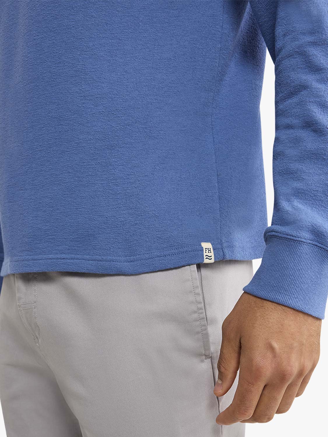 Sea blue terry crewneck sweatshirt worn with light gray pants, showing the ribbed cuff detail.