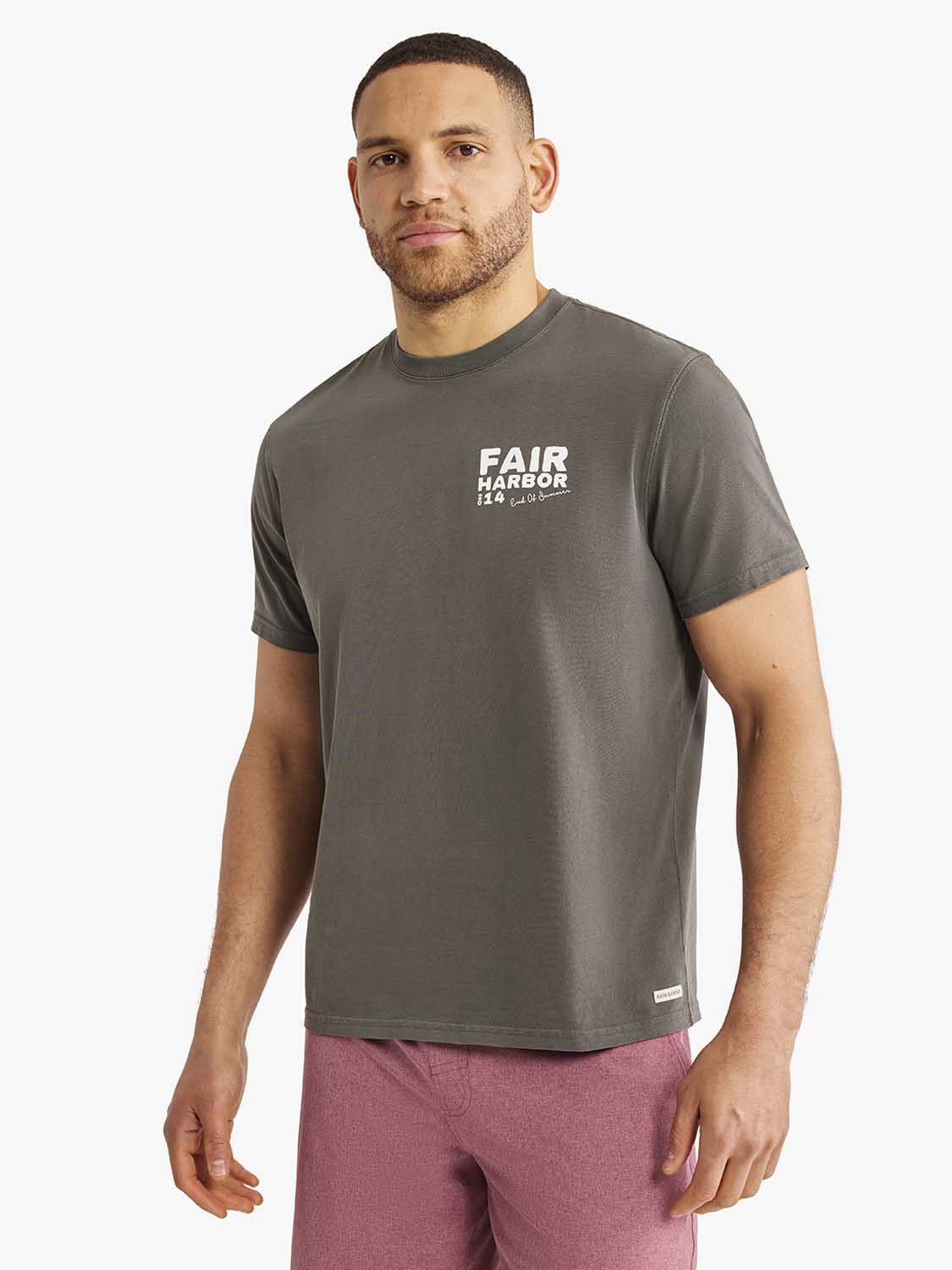 Man wearing a charcoal gray graphic tee with Fair Harbor text print on chest.