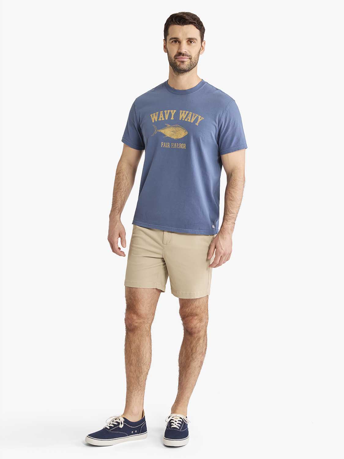 Man wearing a navy blue graphic tee with wavy wavy Fair Harbor text and a fish illustration.