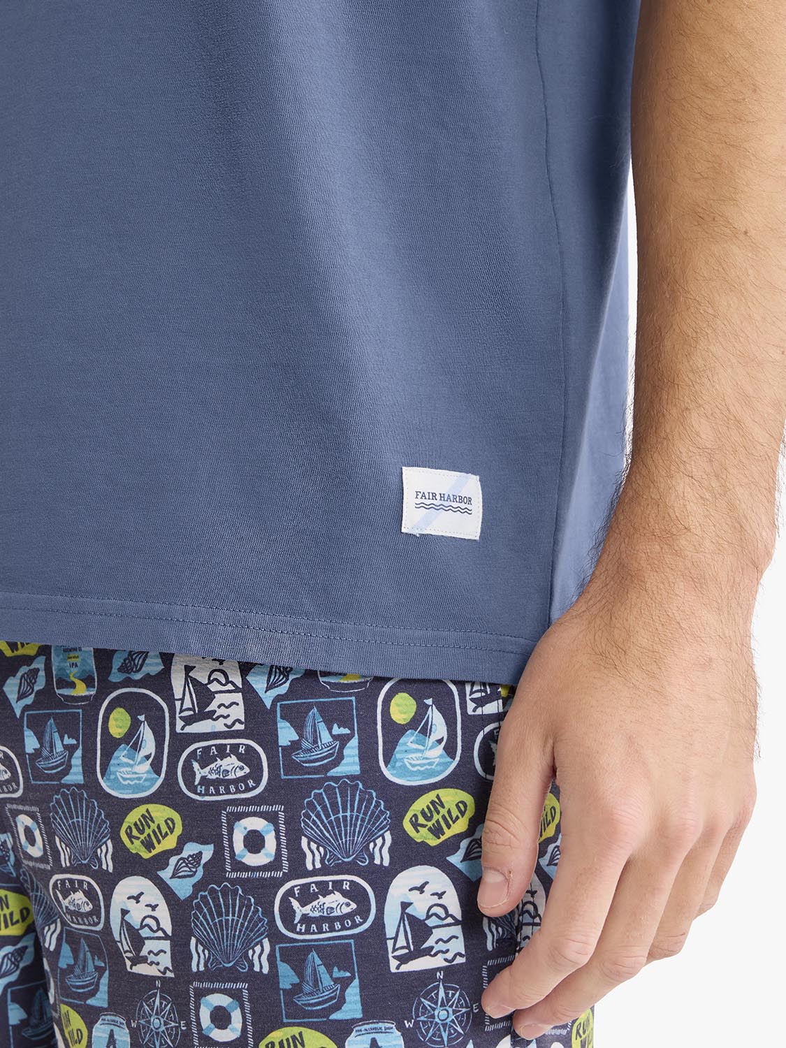 Blue short-sleeve graphic tee with Fair Harbor label on chest worn by man.