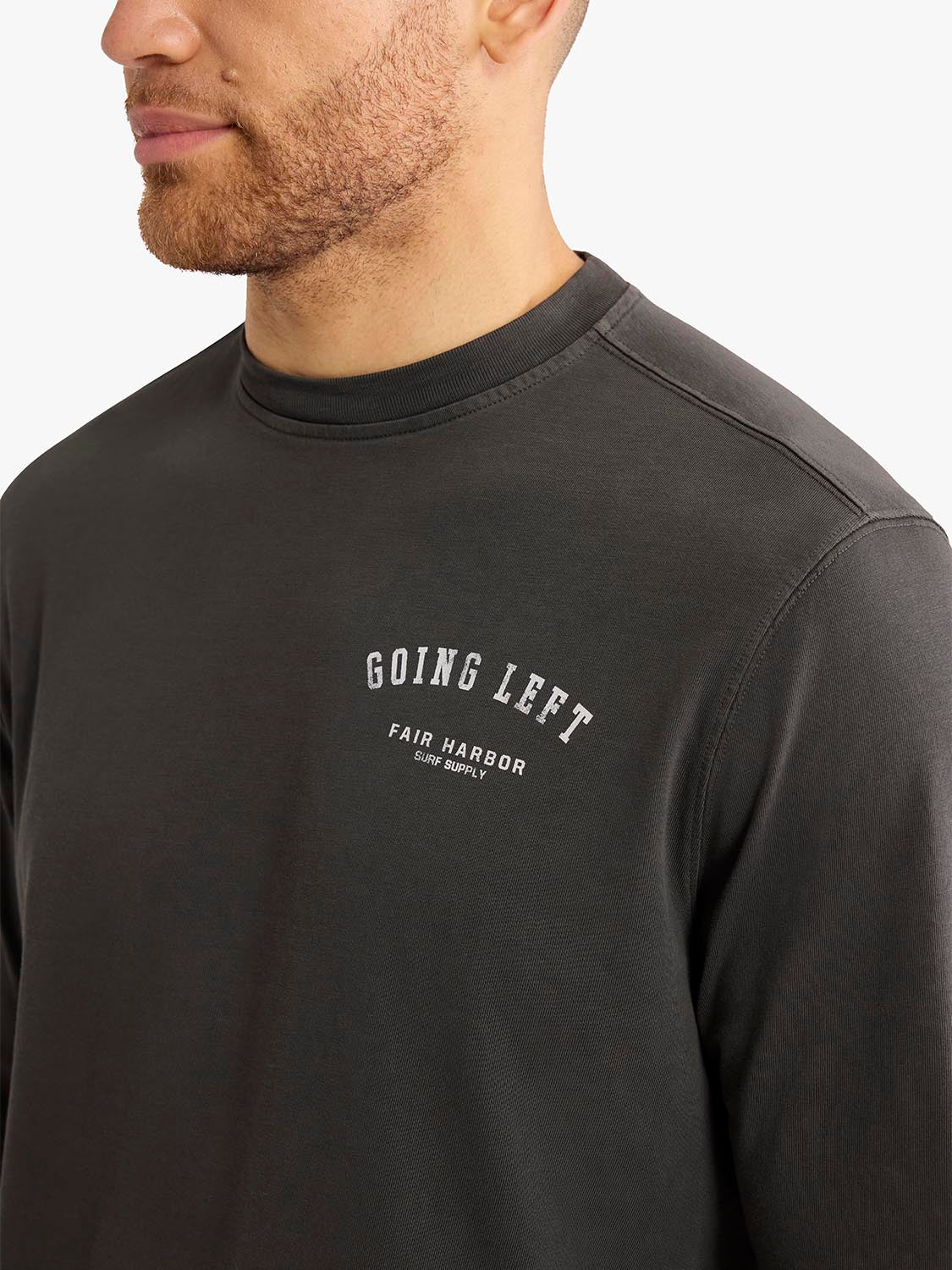 Man wearing a dark charcoal long sleeve graphic tee with 