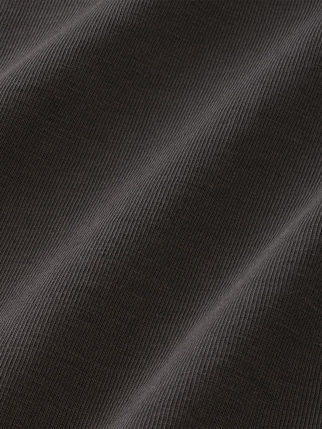 Charcoal gray long sleeve graphic tee with ribbed fabric texture and subtle directional design pattern.