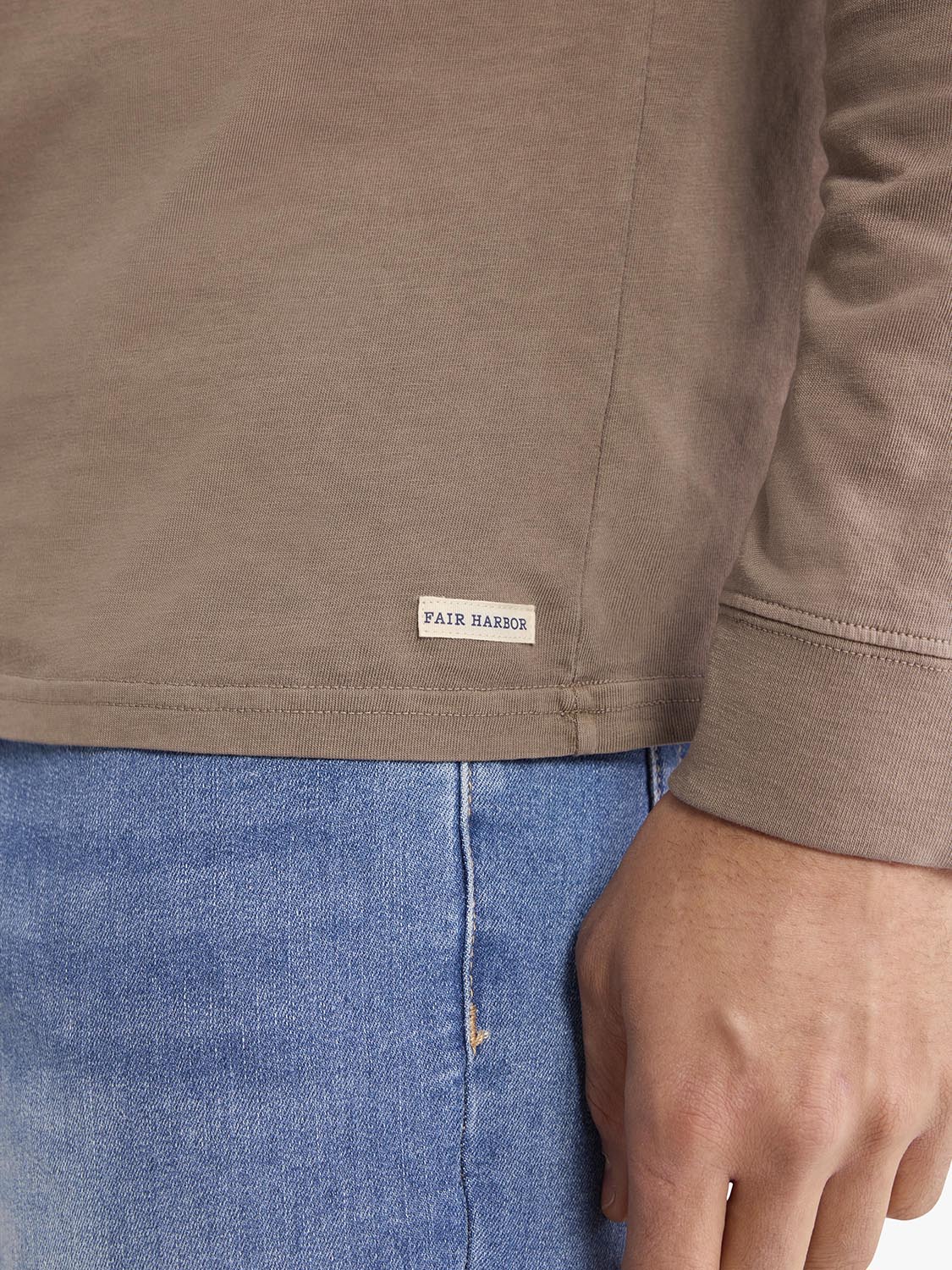 Taupe long sleeve tee with Fair Harbor label visible on the chest area and blue denim shorts.