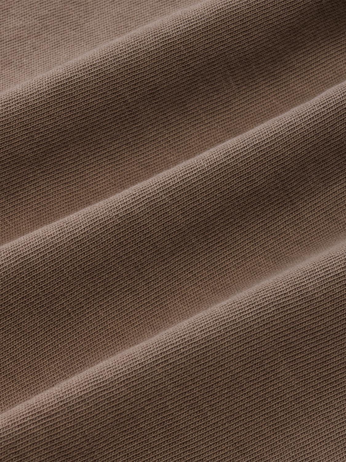 Beige long sleeve shirt with ribbed knit fabric texture and subtle folds throughout.