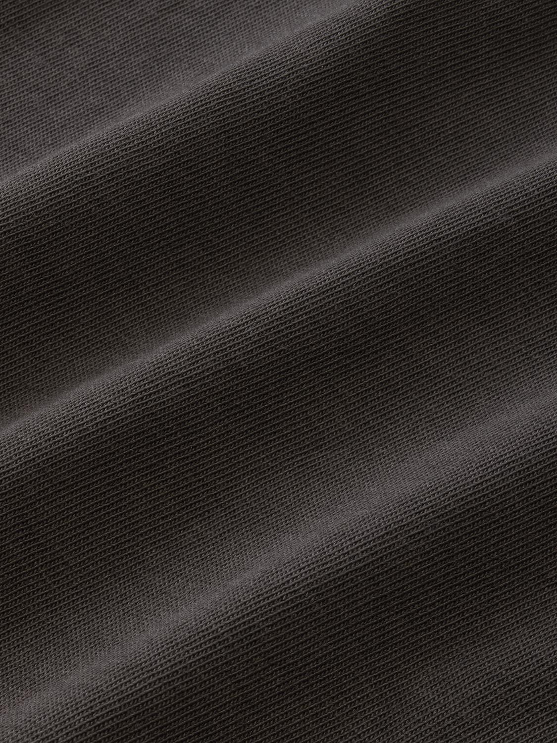 Black long sleeve tee with textured knit fabric and subtle diagonal folds throughout.