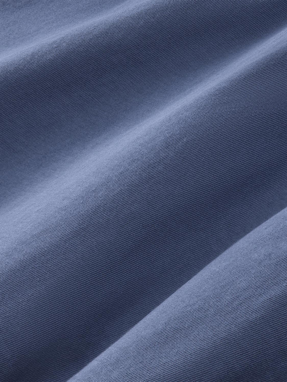 Close-up of navy blue long sleeve tee fabric showing textured knit weave and natural folds.