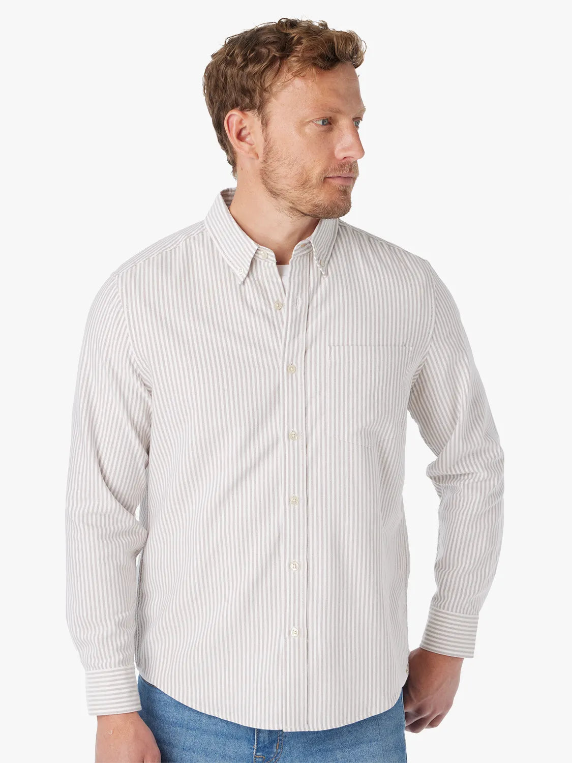 Man wearing a light oak striped oxford shirt with a button-down collar and long sleeves.