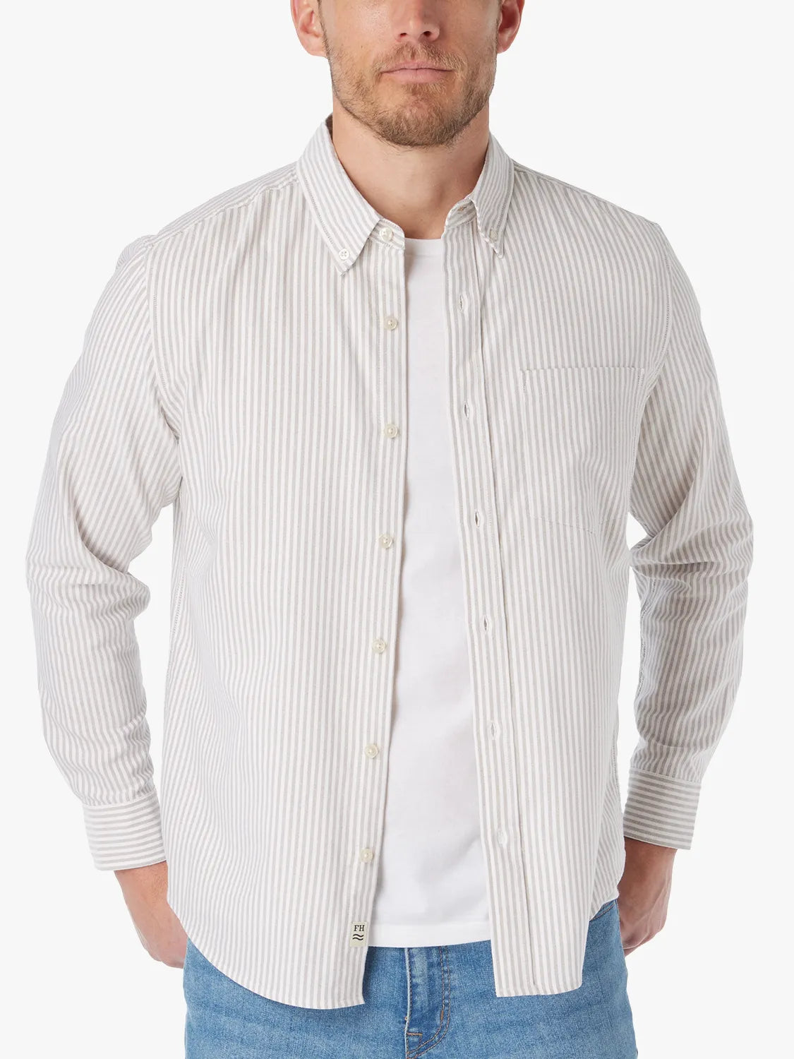 Man wearing a cream and beige vertical striped Oxford shirt with button front and chest pocket.