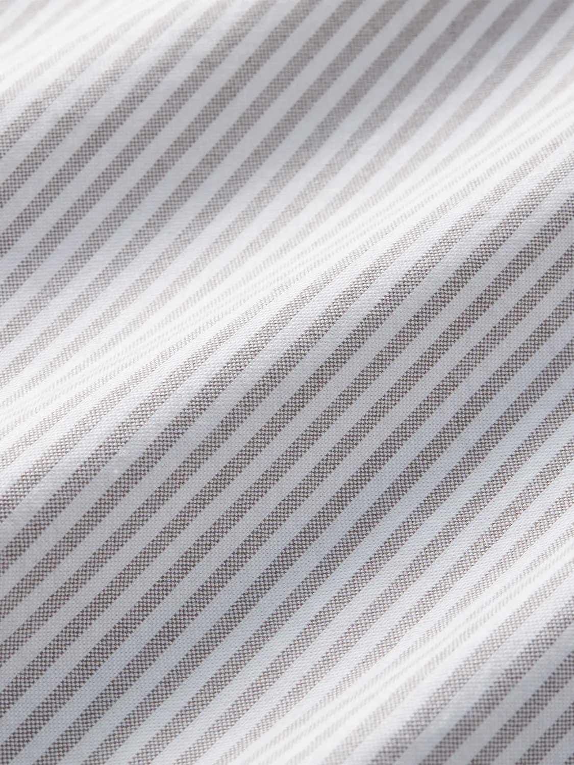 Close-up of white and oak striped oxford shirt fabric showing diagonal woven texture pattern.