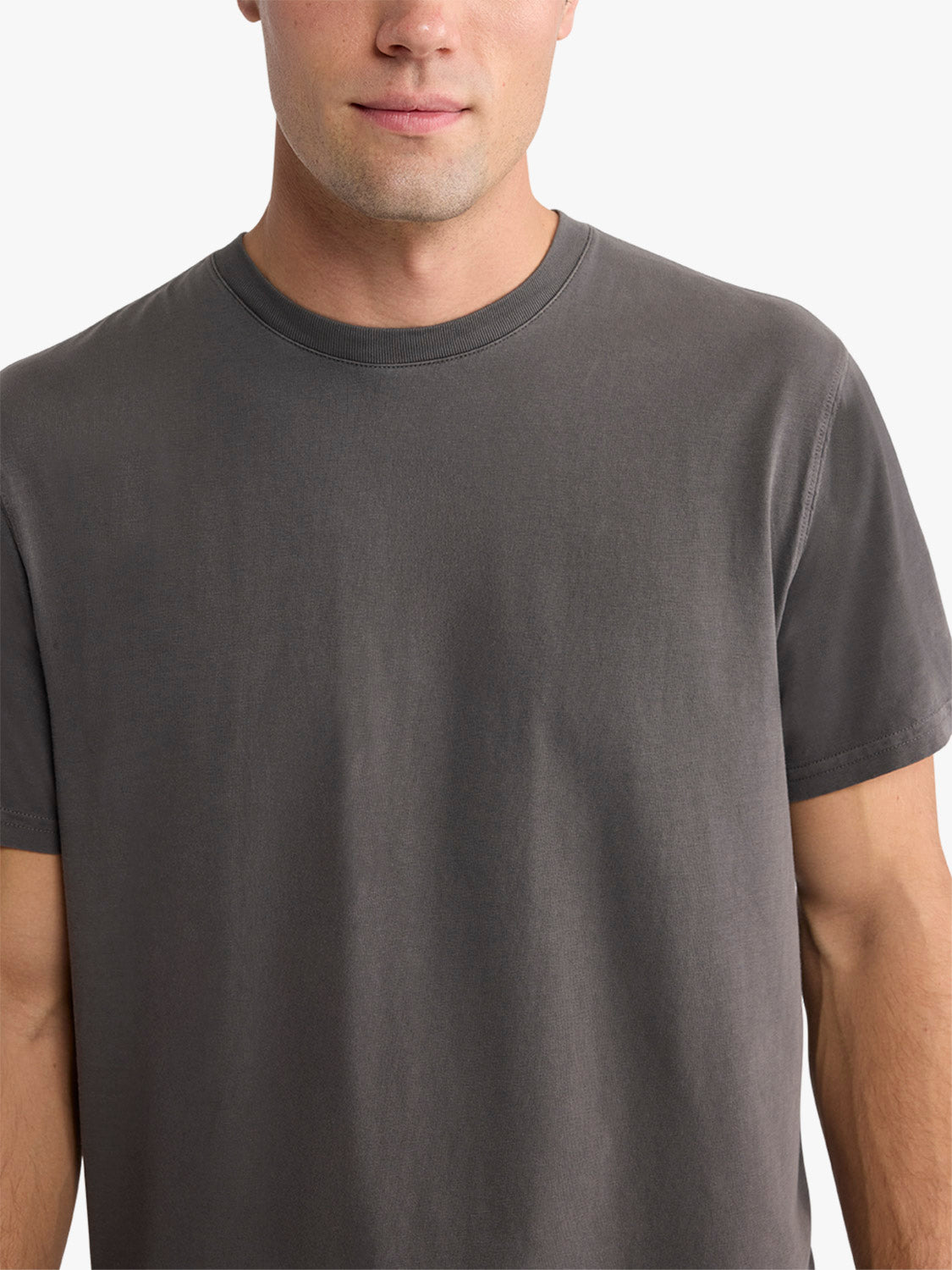 Man wearing a dark gray short-sleeve crew neck t-shirt against a plain white background.