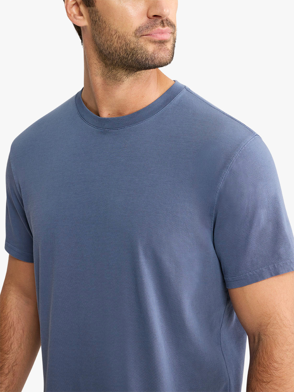 Man wearing a navy blue crewneck short-sleeve t-shirt against a white background.
