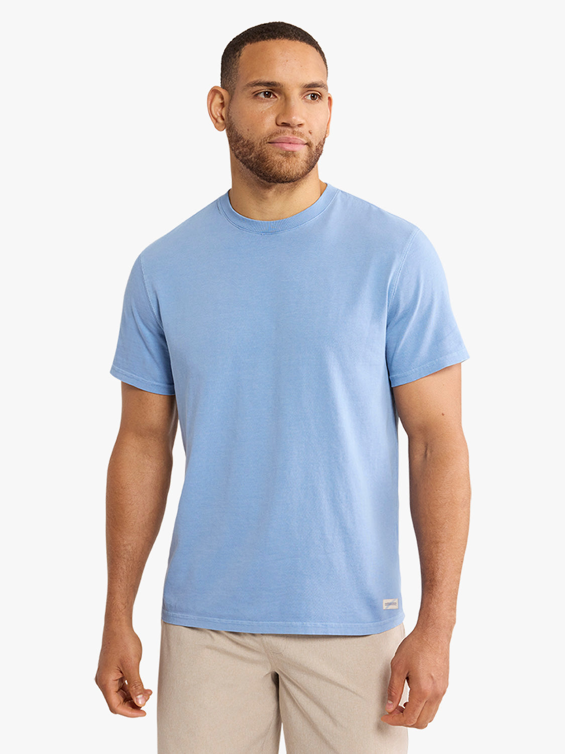 Man wearing a light blue short-sleeve crew neck t-shirt with khaki pants.