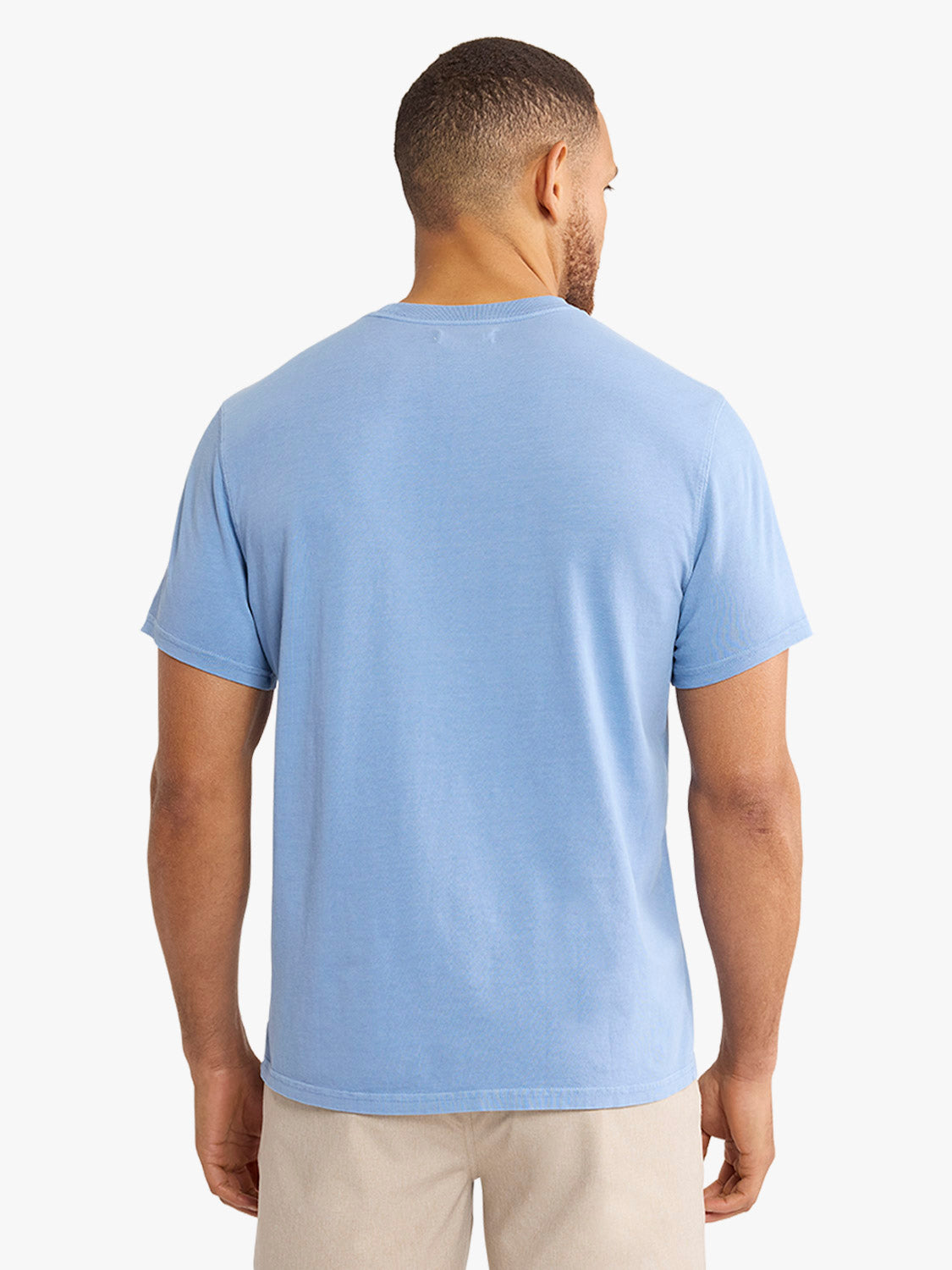 Man wearing a light blue short-sleeved crewneck t-shirt, shown from the back view.