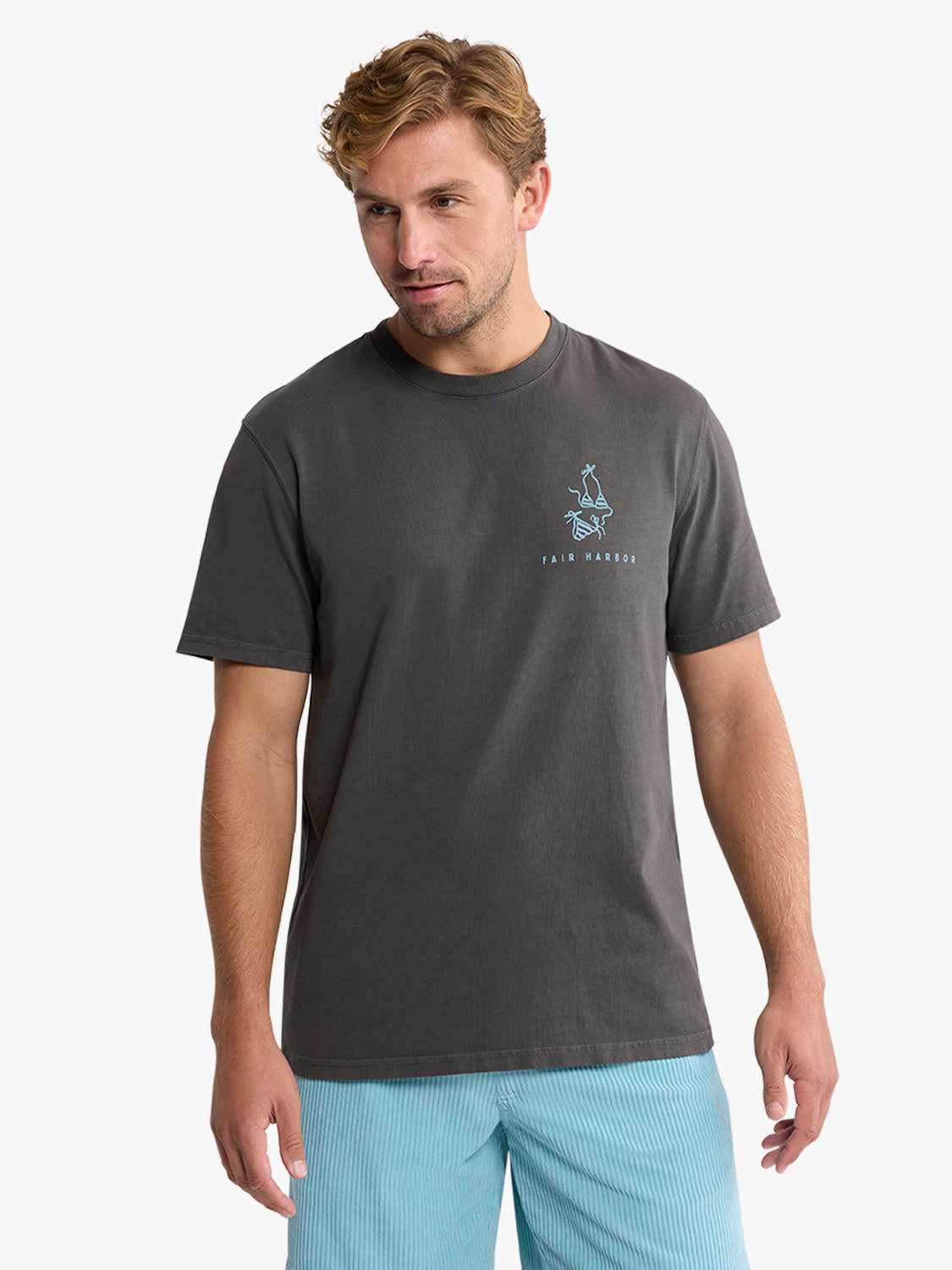 Man wearing charcoal gray t-shirt with small graphic and text on chest.