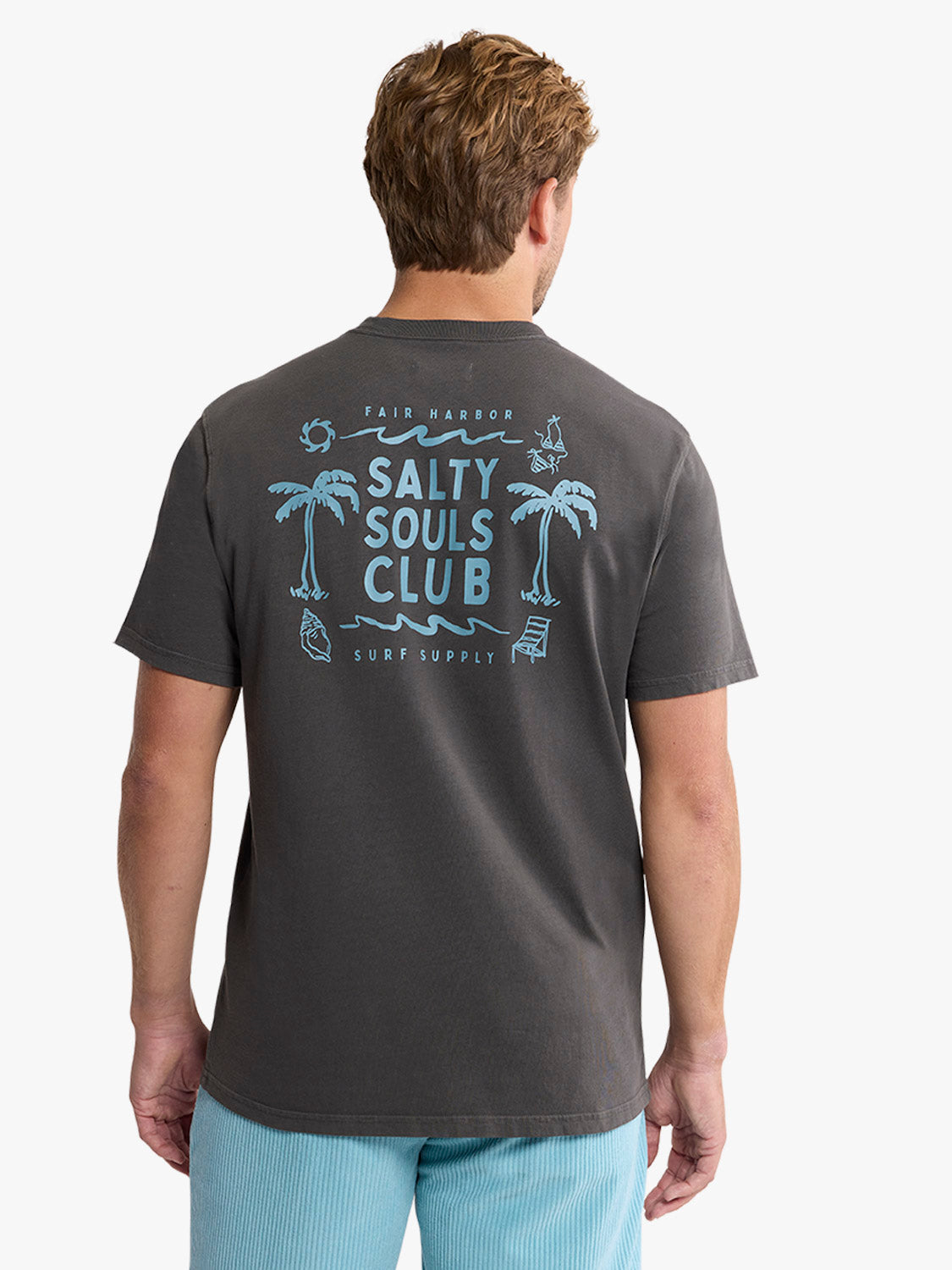 Man wearing dark gray short-sleeve t-shirt with blue Salty Souls Club graphic and palm tree designs on back.