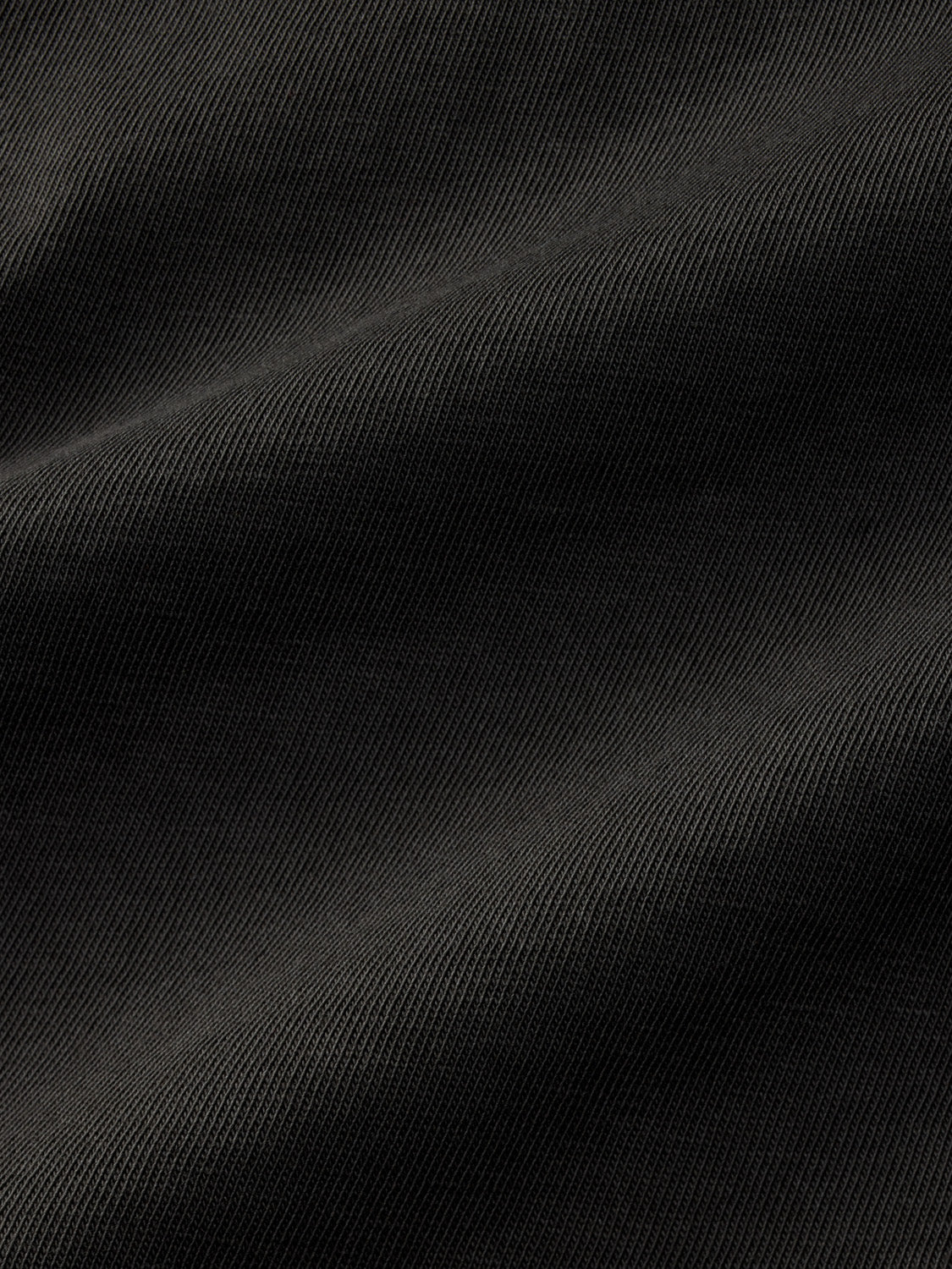 Black graphic tee with ribbed texture and diagonal wave pattern across the fabric surface.