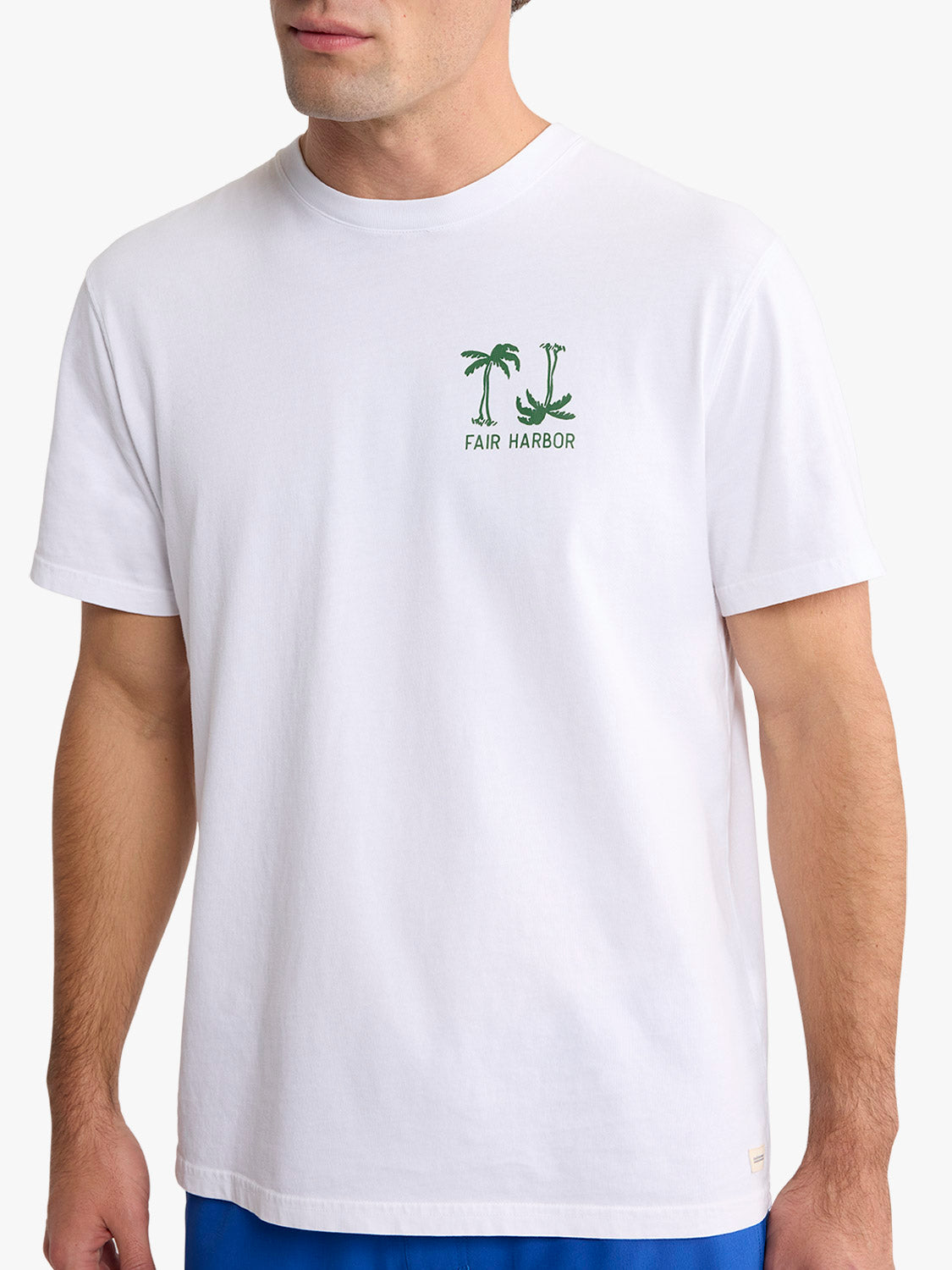 White t-shirt with green checkered palm tree graphic and Fair Harbor text on chest.