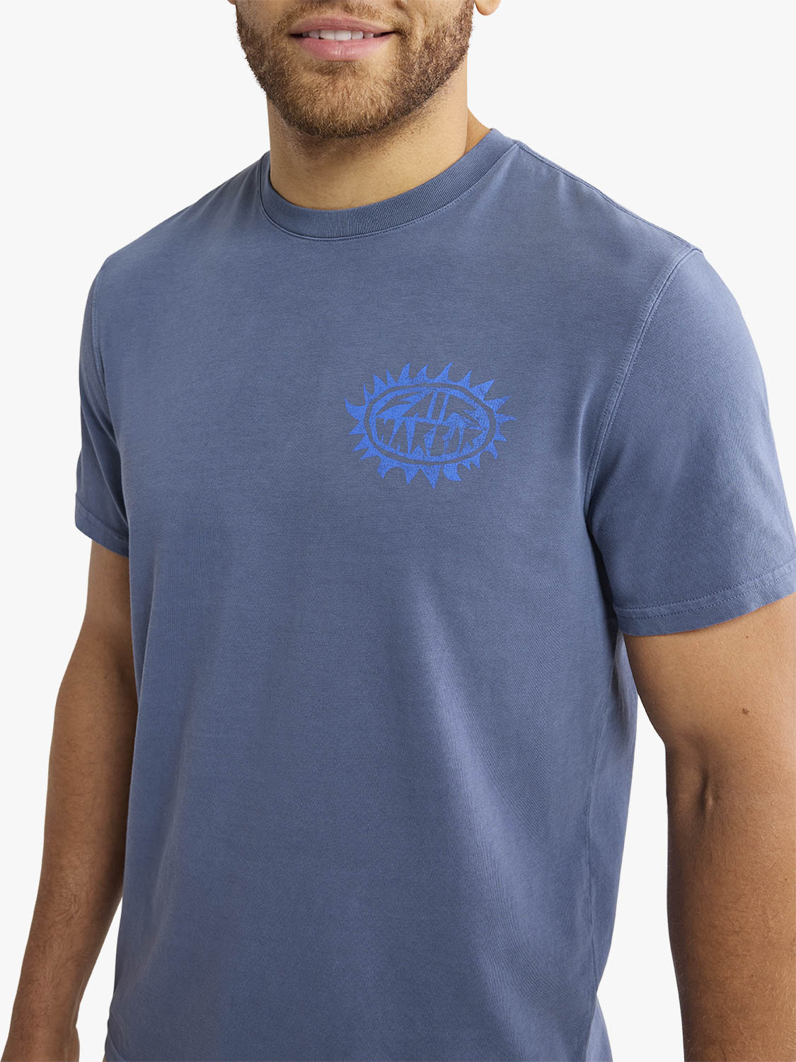 Man wearing a blue tonal graphic tee with a blue eye design on the chest.