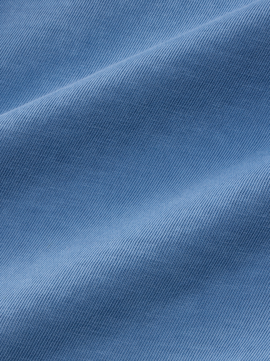 Blue cotton t-shirt with diagonal wave pattern texture throughout the entire fabric.