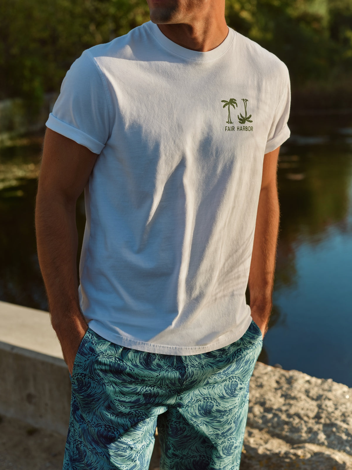 White short-sleeve graphic tee with palm tree print and Fair Harbor text on chest.