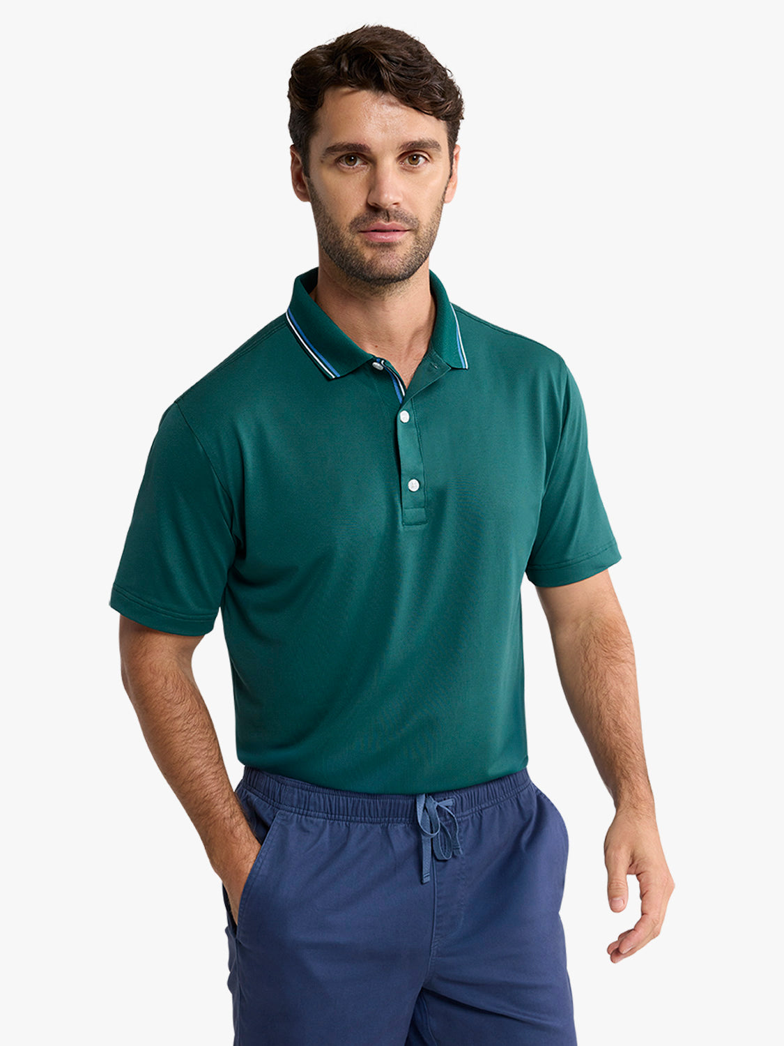 Man wearing a fairway green pique polo shirt with white-tipped collar and navy shorts.