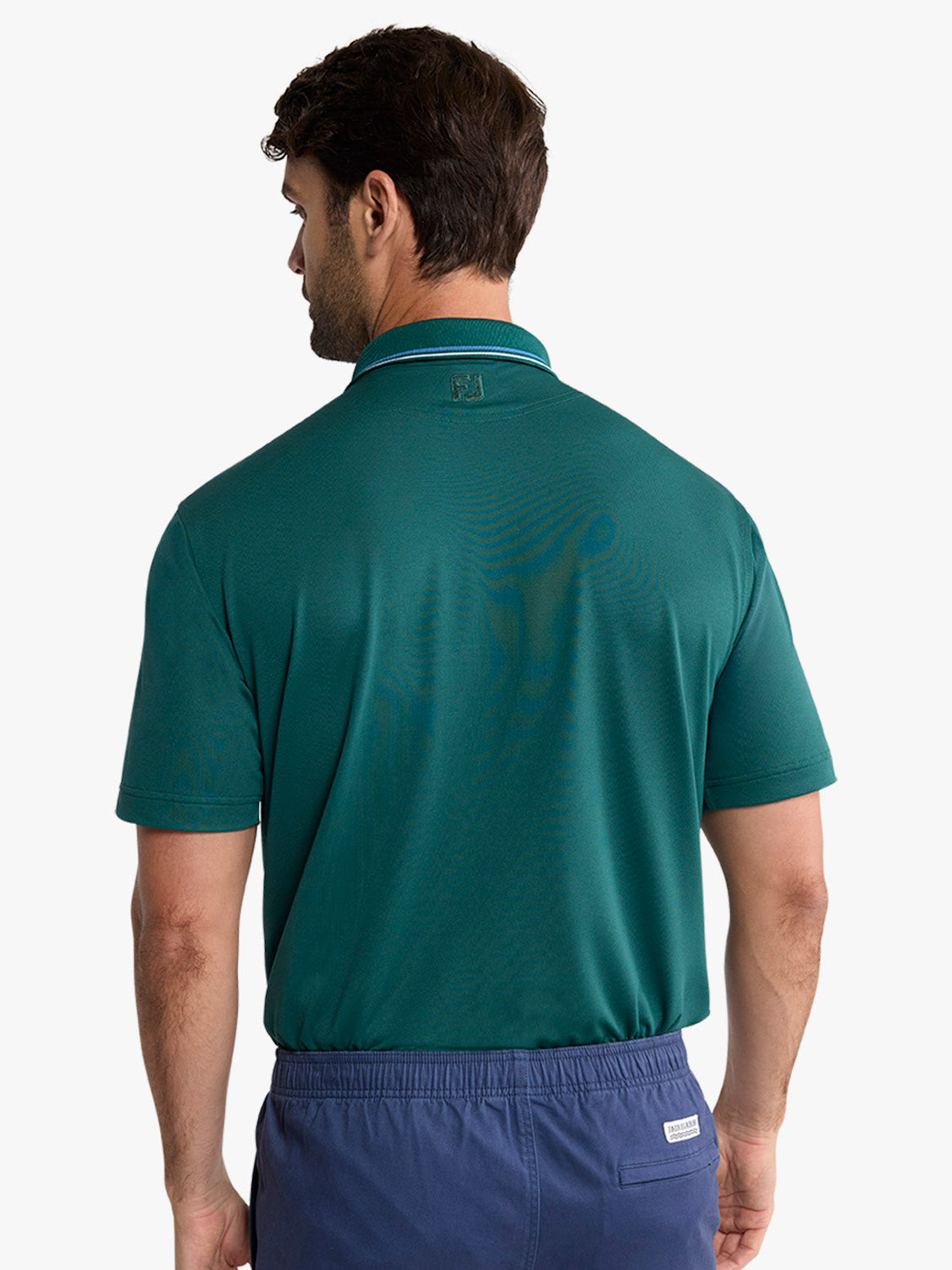 Man wearing a fairway green pique polo shirt with a striped collar, shown from the back.