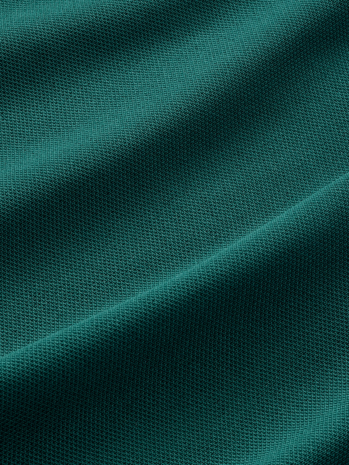 Fairway green pique polo shirt fabric showing textured weave with natural folds and draping.