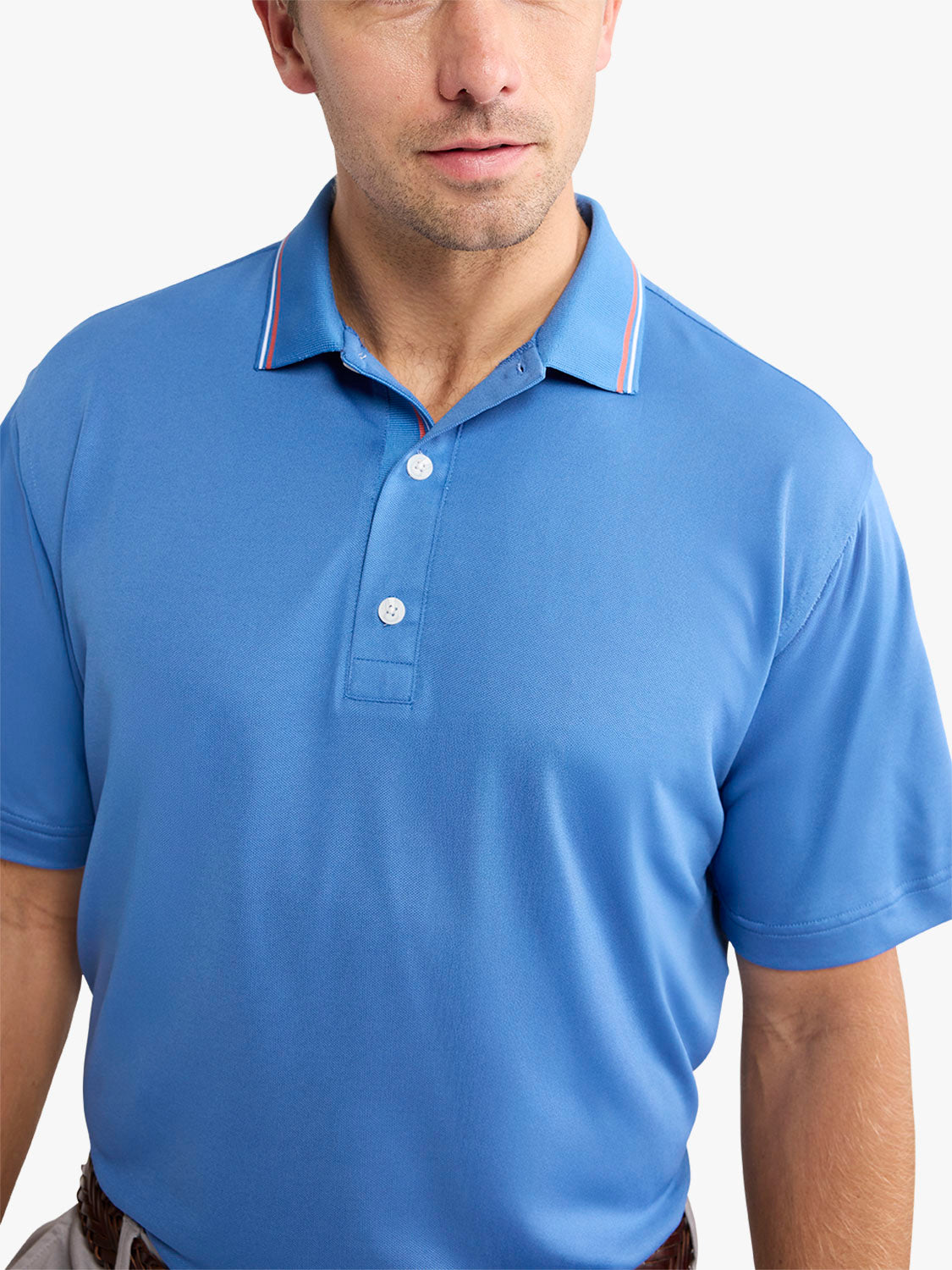 Man wearing ocean blue pique polo shirt with white buttons and striped collar trim.