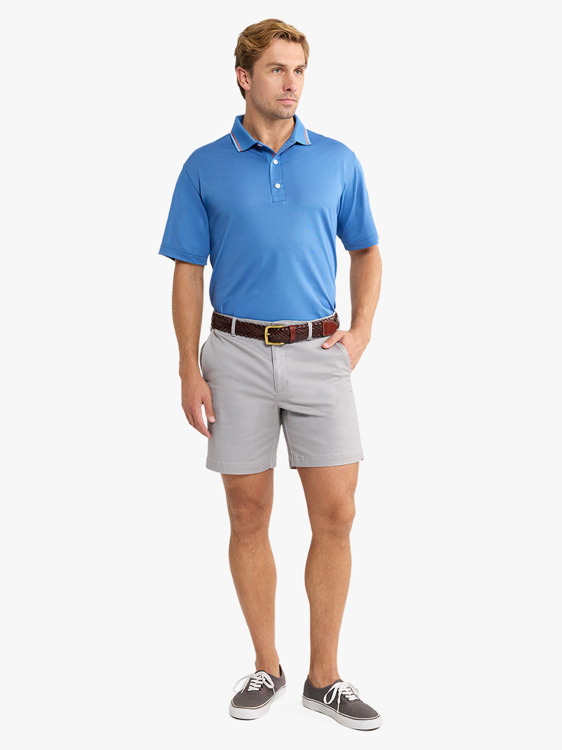 Man wearing ocean blue short-sleeve pique polo shirt with gray shorts and brown belt.