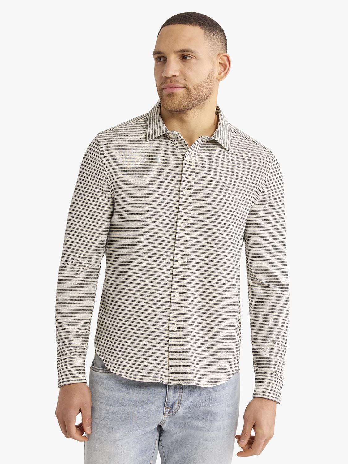 Man wearing a long-sleeved button-up shirt with horizontal gray and white stripes throughout.