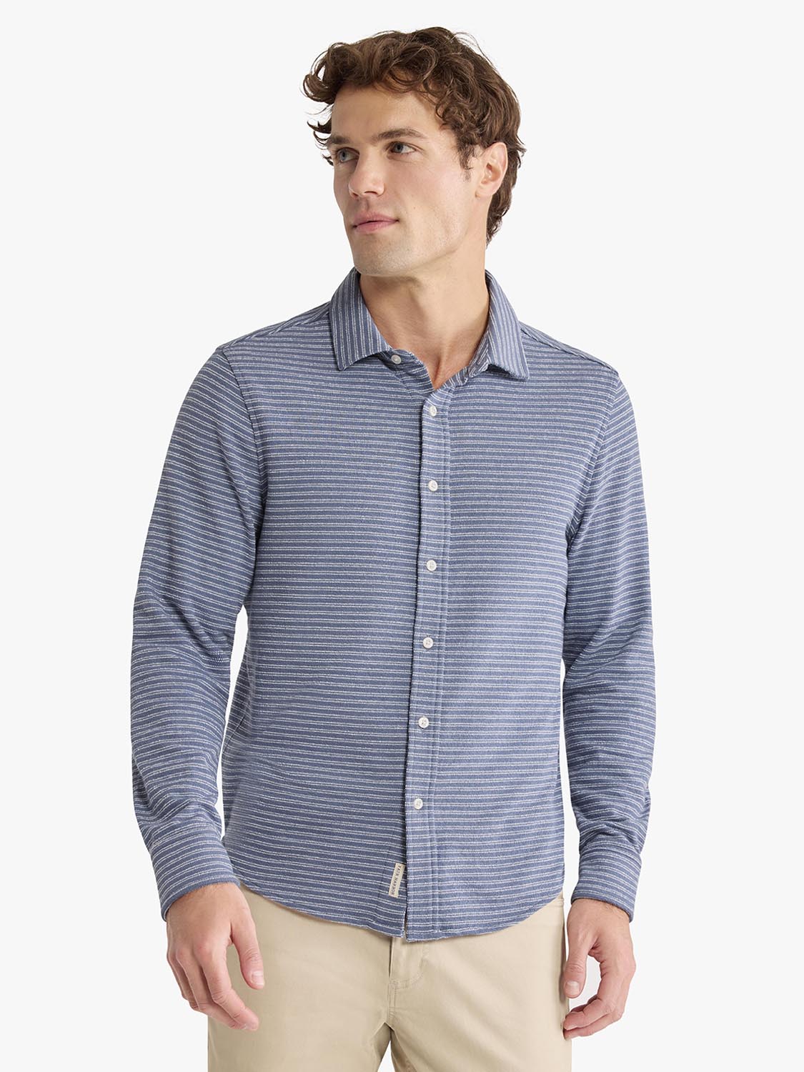 Man wearing blue and white striped button-up shirt with long sleeves and collar.