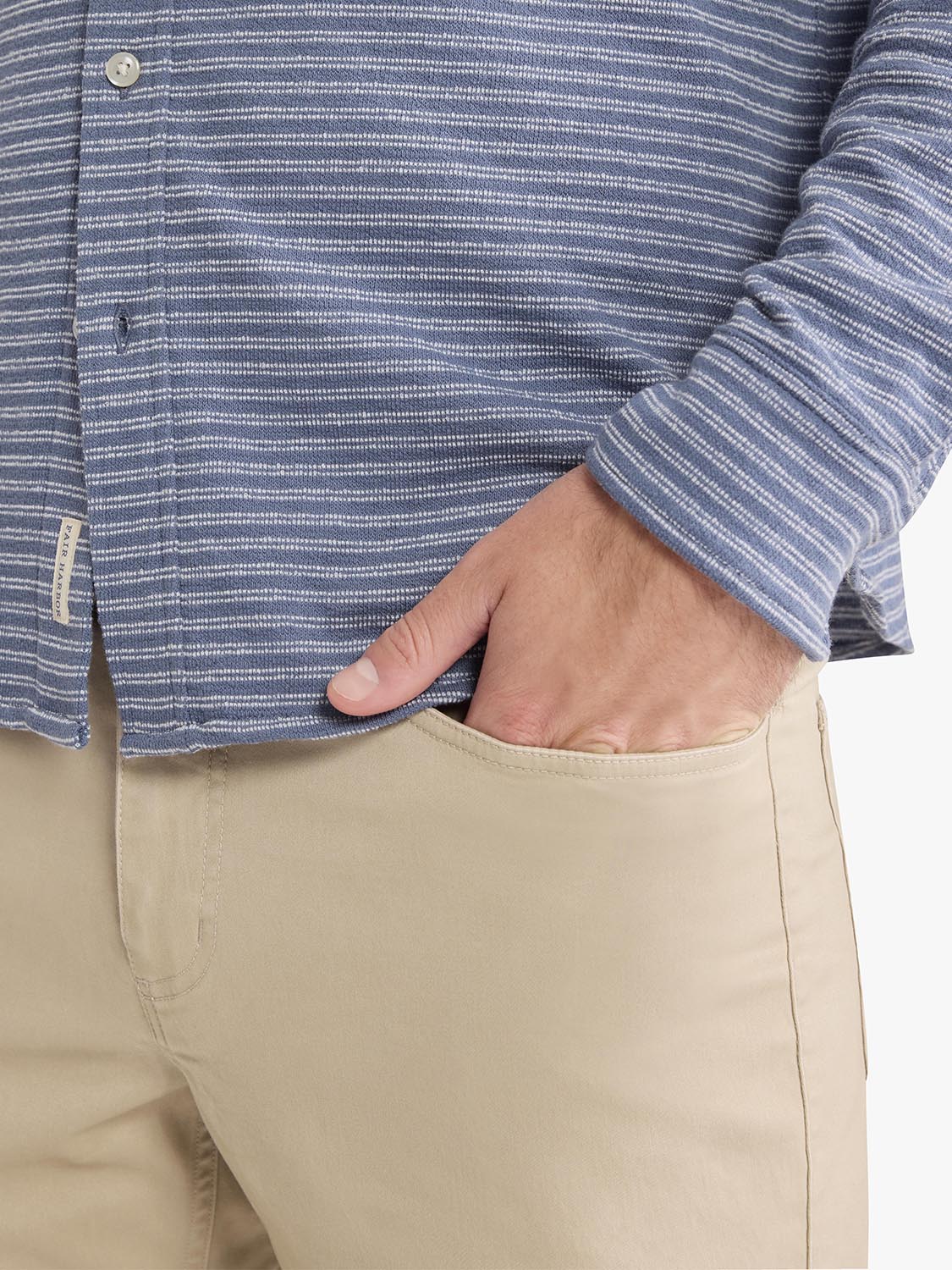 Blue and white striped terry button-up shirt worn with khaki pants, showing textured fabric detail.