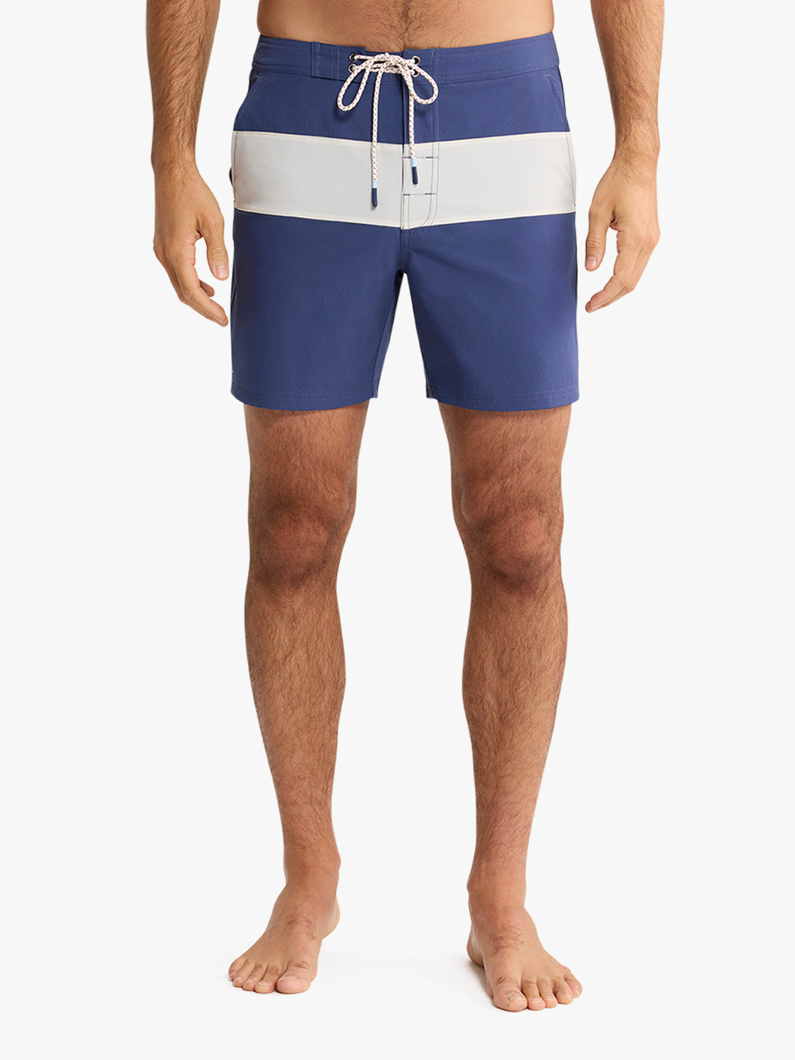 Man wearing navy and white striped board shorts with a drawstring waistband.