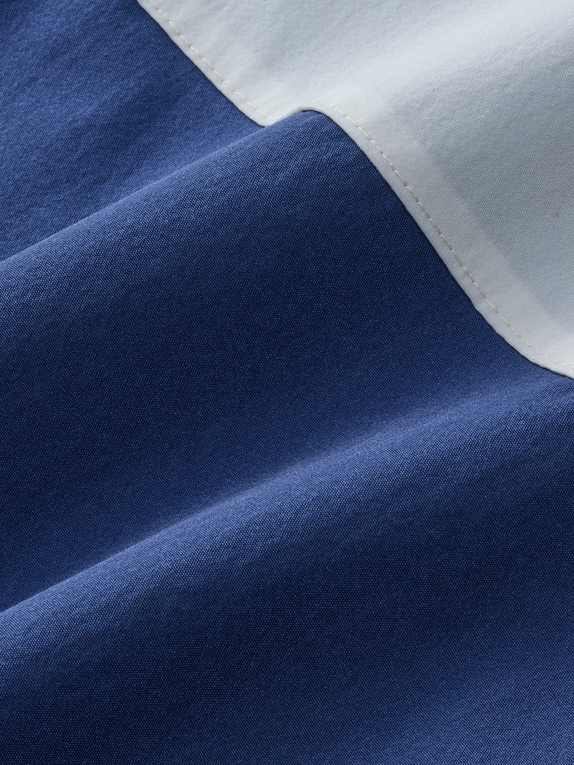 Navy and white striped board short fabric showing textured weave and color block design detail.