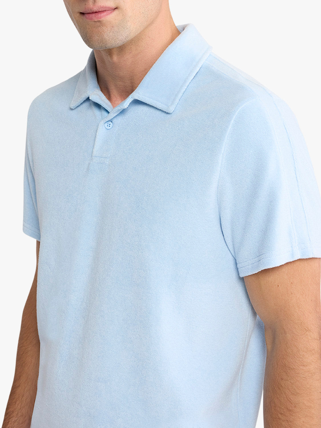 Man wearing a light blue short-sleeve polo shirt with a collared neckline and button placket.