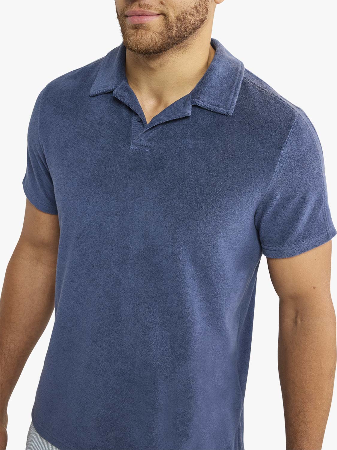 Man wearing a navy blue short-sleeved terry cloth polo shirt with a collared neckline.