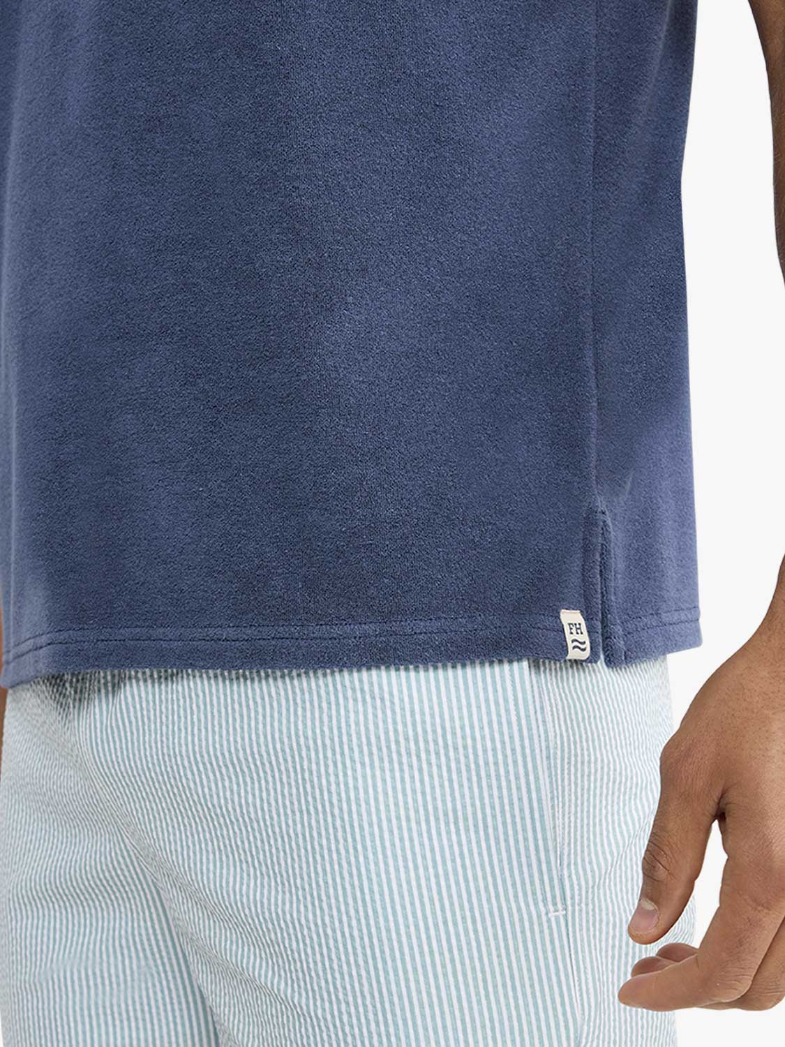 Navy terry polo shirt with ribbed white and blue striped shorts on a man.